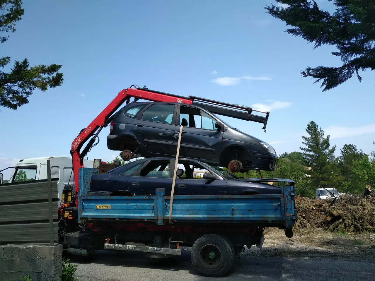 Chargement de deux véhicules à la grue sur un même camion.